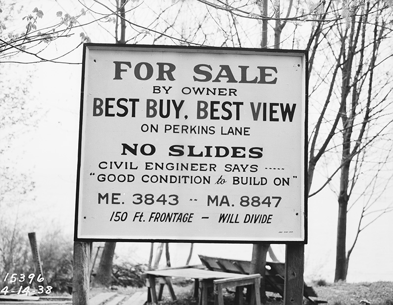 Sign reading "For sale by owner — best buy, best view on Perkins Lane — No slides — Civil engineer says "Good condition to build on" — ME. 3843, MA. 8847 — 150 ft. frontage — will divide" at 2461 Perkins Lane W