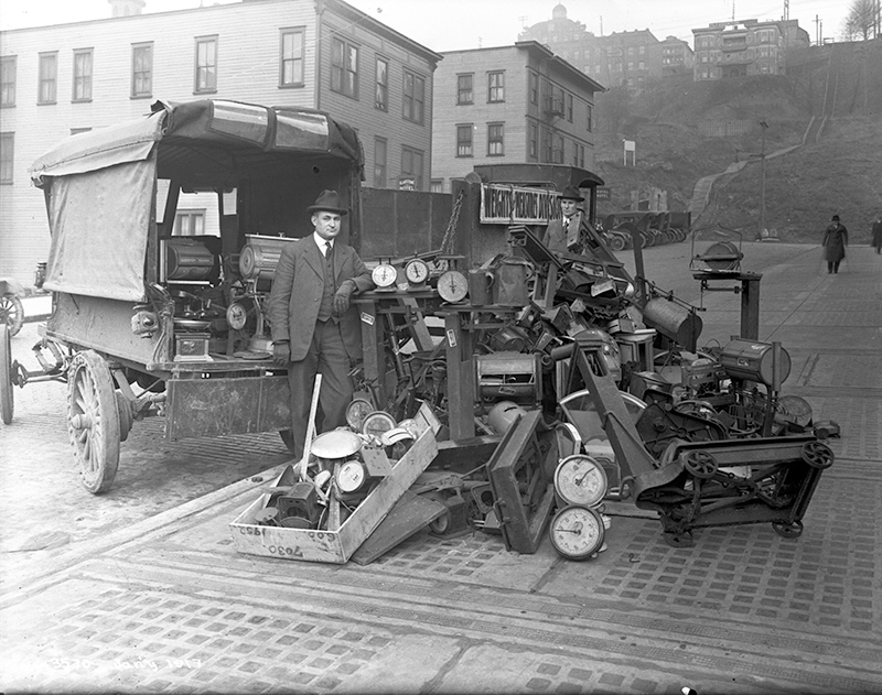 Official from Seattle Weights and Measures Division with confiscated scales standing in Terrace Street