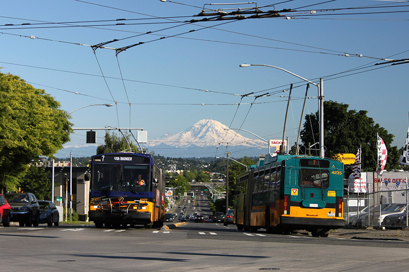 Looking south on Rainier Avenue S from S Jackson Street, with Mount Rainier in background, and two Metro route 7 buses, July 2011. From https://flickr.com/photos/95482862@N00/5914713222