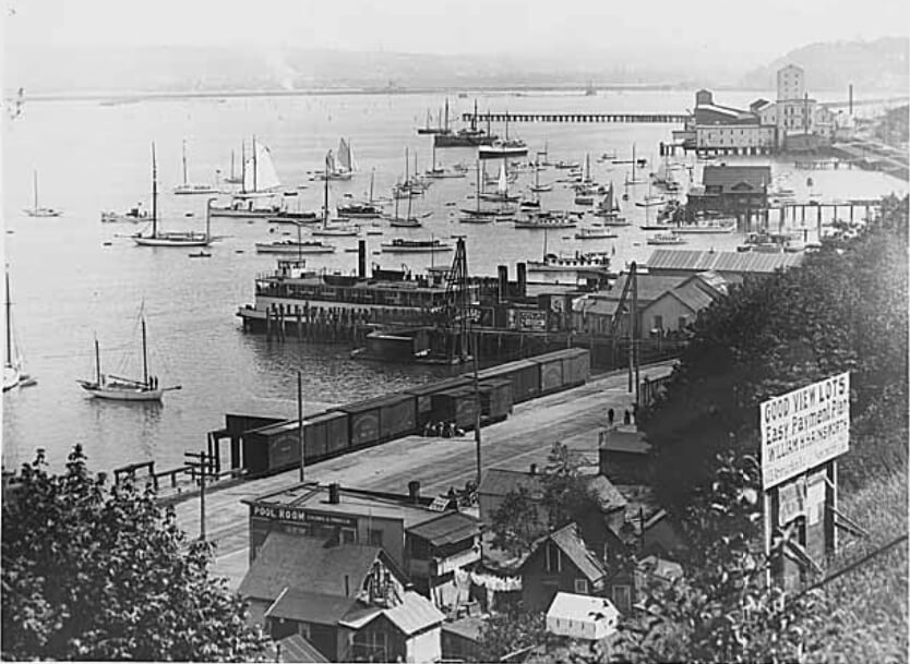 West Seattle Yacht Club fleet and Seattle ferry at pier, 1880s