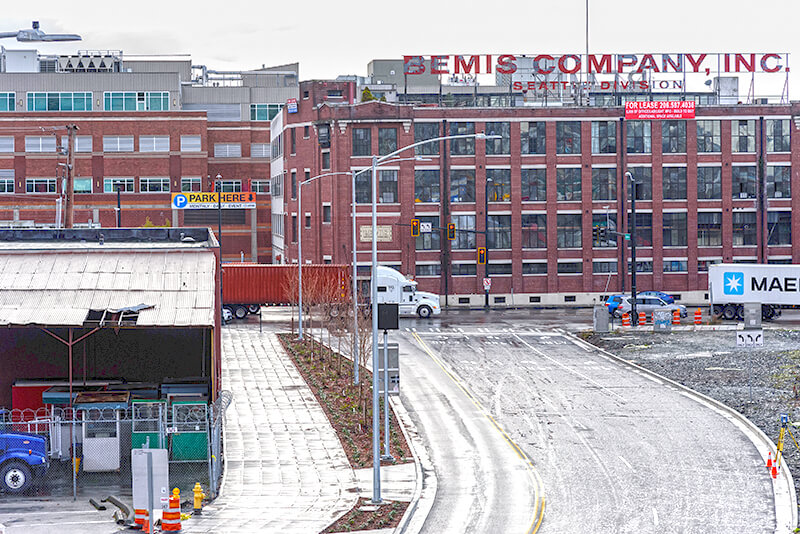 Looking south toward the intersection of Colorado Avenue S and S Atlantic Street, December 2018. The Bemis Building, at 55 S Atlantic Street, housed the local operations of the Bemis Brothers Bag Company from 1905 to 1993.